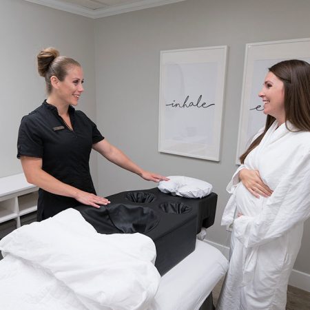 Prenatal massage consultation with therapist and expectant mother.